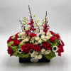Red and white roses arranged in a black rectangular container