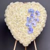 A breathtaking heart-shaped standing tribute crafted with premium white roses and accented