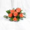 Cluster of bright orange roses arranged into a small bouquet on white fabric