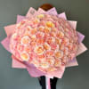 Large bouquet of pale pink and peach roses wrapped in pink paper