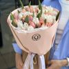 Bouquet of pink and white tulips wrapped in pale pink paper