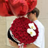 Heart-shaped red balloon bouquet with a round red rose arrangement and white orchids