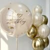 Birthday balloons in cream and gold with a large clear balloon