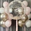 Pastel balloon display with a clear birthday balloon and pink and gold balloons