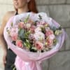 Pink bouquet of roses and ranunculus wrapped in pastel paper