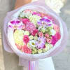 Pink and white mixed bouquet with orchids and roses wrapped in pale paper