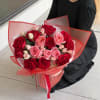 Bouquet of red and pink roses wrapped in red translucent paper