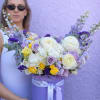 Lavender hatbox bouquet of white, purple, and yellow flowers