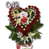 Heart-shaped bouquet of red roses with lilies, chocolates, and a teddy bear