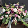 Large pink and white floral arrangement with roses and calla lilies