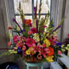 Large mixed flower arrangement in a wicker basket with lilies and gerbera daisies