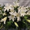 Large white lily arrangement with dense greenery