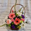 Basket arrangement with pink gerberas, roses, and white daisies