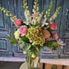 Tall mixed flower arrangement in a clear glass vase