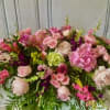 Large pink and white floral arrangement with roses and mixed blooms