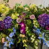 Large mixed floral spray with purple, yellow, blue, and pink blooms