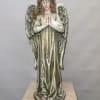 Decorative angel statue with floral crown and folded hands