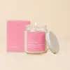 Lit candle in a glass jar with a pink box and lid