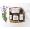 Lavender sprigs beside a gift box with soap, candle, spray, and oil