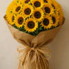 Bouquet of bright yellow sunflowers wrapped in brown paper
