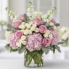 Pink and white roses with hydrangeas in a clear glass vase
