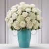 White roses and hydrangeas in a turquoise vase with pearl strands