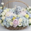 Basket of pastel flowers with a plush elephant in the center