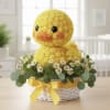 Yellow duck plush in a flower basket with daisies and ribbon