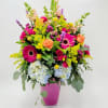 A bright splash of color containing snapdragons, roses, spray roses, mums, gerbera