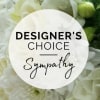 White floral sympathy arrangement with a designer's choice label
