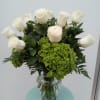 White roses and green hydrangeas in a clear glass vase