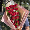 Bouquet of red roses wrapped in pink paper
