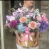 Large pastel bouquet in a gold box with a pink ribbon