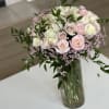 Bouquet of pale pink and white roses in a glass vase