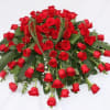 Large bouquet of red roses with greenery on a white background