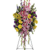 Standing funeral spray with pink lilies, yellow daisies, and purple flowers