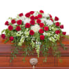Red roses and white flowers arranged on a casket