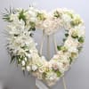 Heart-shaped white floral wreath on an easel