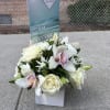 A clean, airy cluster of white roses, lilies, orchids, daisies and carnations