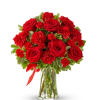 Red roses and carnations in a clear glass vase with a red ribbon