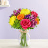 Colorful bouquet of roses, gerbera daisies, and chrysanthemums in a glass vase