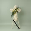 Elegant white funeral cross arrangement. Designed with a mix of roses, spray