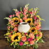 Colorful floral wreath around a white ceramic urn