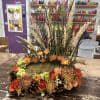 A low, circular wreath arrangement that captures the warmth of fall-perfect as