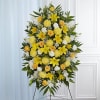 Standing floral spray with yellow and white flowers on an easel