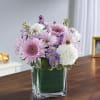 Pink and white flowers arranged in a clear square vase