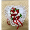 Heart-shaped bouquet of red and white flowers with lace trim and red ribbon