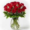 Red roses arranged in a clear glass vase with baby's breath