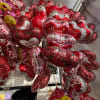 Cluster of heart-shaped Valentine balloons in red, pink, and silver
