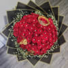 Bouquet of red roses with white filler and black-gold wrapping
